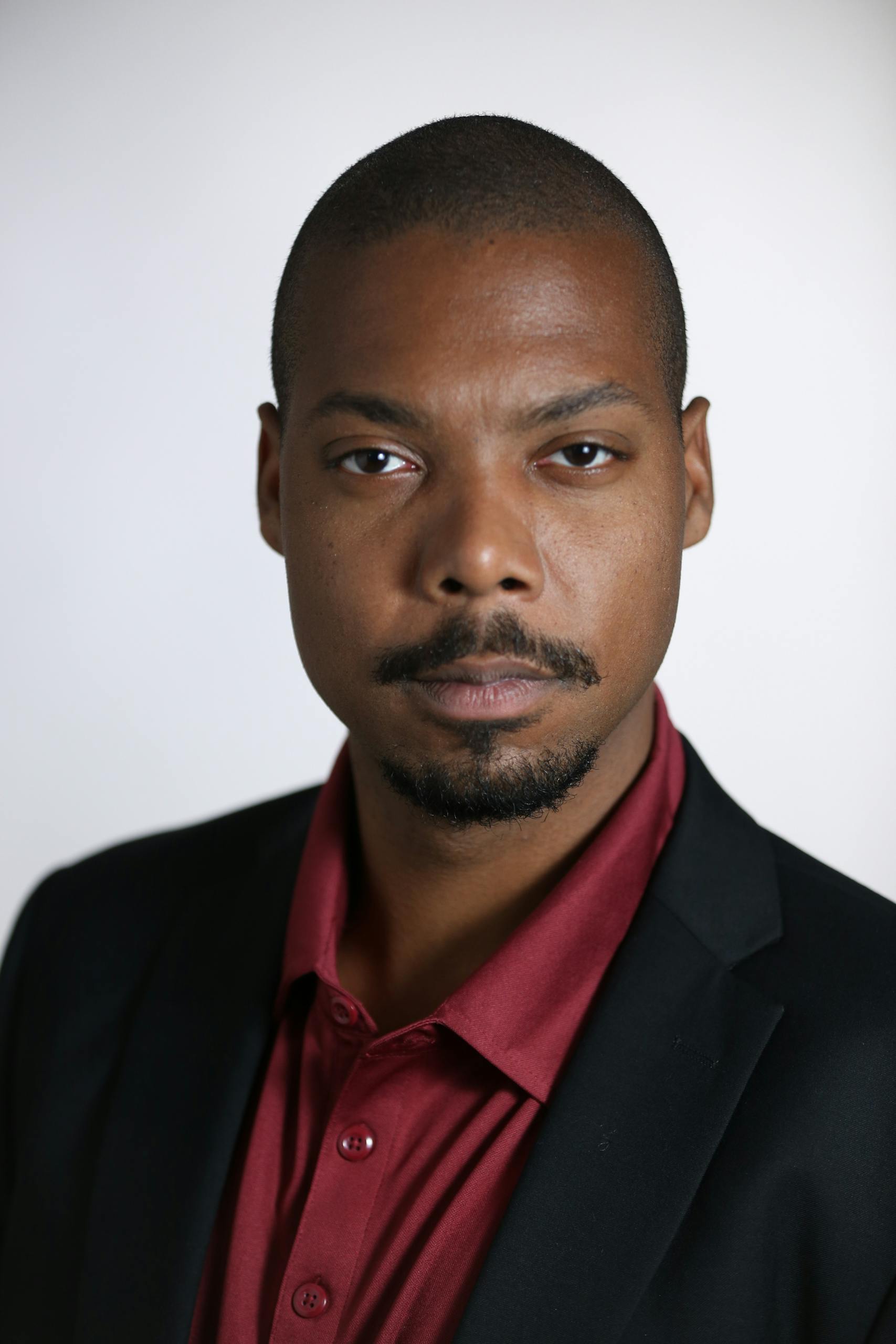 Portrait of a confident African American businessman in formal wear on a white background.