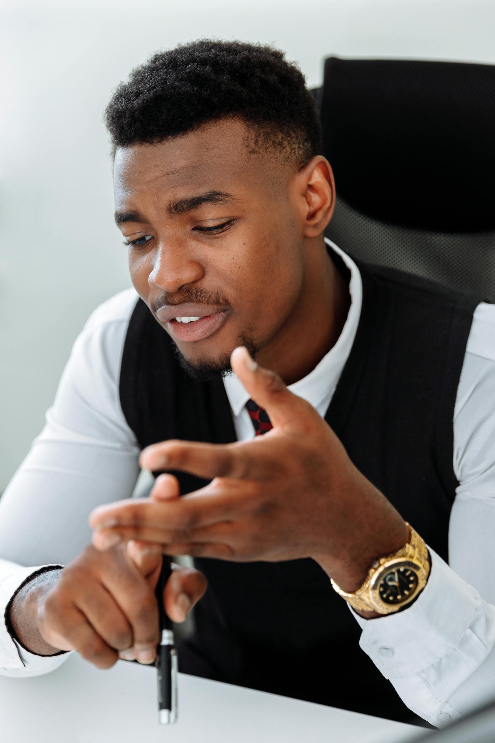 Portrait of a confident businessman in a modern office, communicating with gestures.